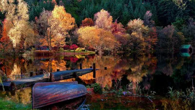 Обои на рабочий стол Осенний пейзаж с озером, мостиком на воде, деревьями  по берегам с осенней листвой, перевернутой на берегу деревянной лодкой,  деревянной купальне на воде, обои для рабочего стола, скачать обои,