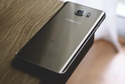 серебряный смартфон Samsung Galaxy на коричневом деревянном столе ·  Бесплатные стоковые фото