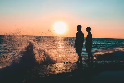 Двое мужчин, стоящих на берегу моря · Бесплатные стоковые фото
