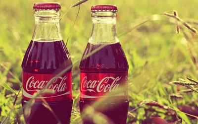 Обои на рабочий стол Бутылка кока-колы / coca-cola стоит на коробках с  напитком, обои для рабочего стола, скачать обои, обои бесплатно