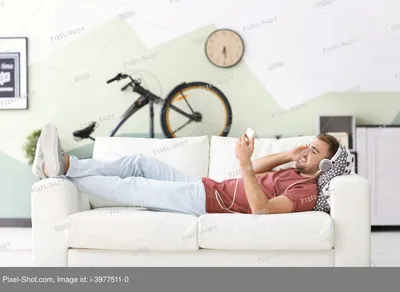Счастливая женщина отдыха на диване комфорта дома Стоковое Фото -  изображение насчитывающей здоровье, женщина: 213357096