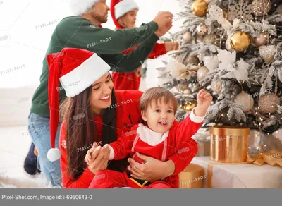 Девушка с новогодним подарком в руках сидит дома возле елки стоковое фото  ©Lobachad 432709636