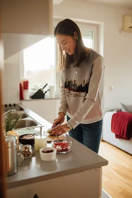 красивая девушка стоит на кухне и держит на руках ребенка a beautiful woman  stands in the kitchen holding a baby Stock-Foto | Adobe Stock