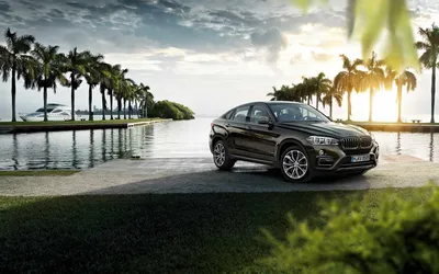 Обои на рабочий стол Мужчина едет за рулем бордового BMW X6 2019 по трассе  на фоне гор, обои для рабочего стола, скачать обои, обои бесплатно