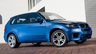 Обои на рабочий стол Автомобиль BMW X5 едет по улице ночного мегаполиса,  обои для рабочего стола, скачать обои, обои бесплатно